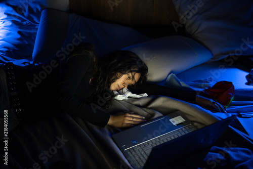 Canvas Print Mujer triste acostada en la cama de noche con la computadora