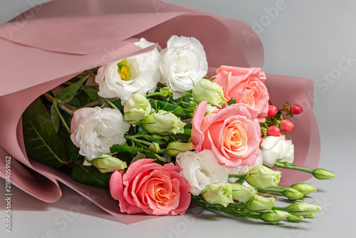 Bouquet of roses and eustoma wrapped in paper pink wrapper