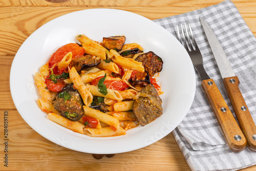Pasta with baked eggplants, tomatoes, fresh basil and grated cheese