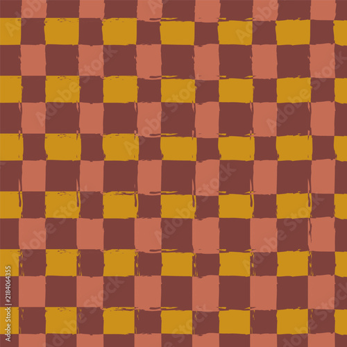 Seamless abstract checkered pattern in autumn colors with hand drawn brush lines ideal for textiles or backgrounds