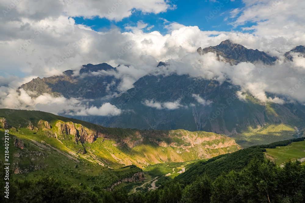 Fototapeta premium Scenic stormy alpine landscape over Kazbek mountains in Kazbegi, Stepantsminda, Georgia 