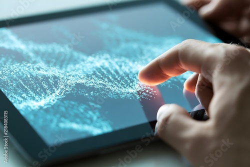 Futuristic scientific concept showing a human hand interacting with a glowing digital DNA double helix on a tablet screen. Advanced genetic sequencing and bioengineering technology.