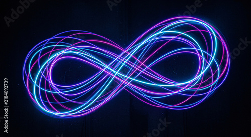 Endless neon linear data infinity symbol glowing on a dark background