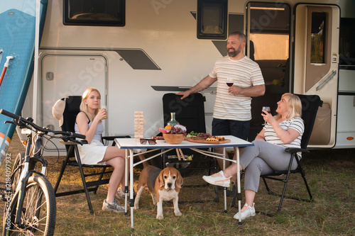 Obraz na plátně A happy family is resting nearby near their motorhome in the forest