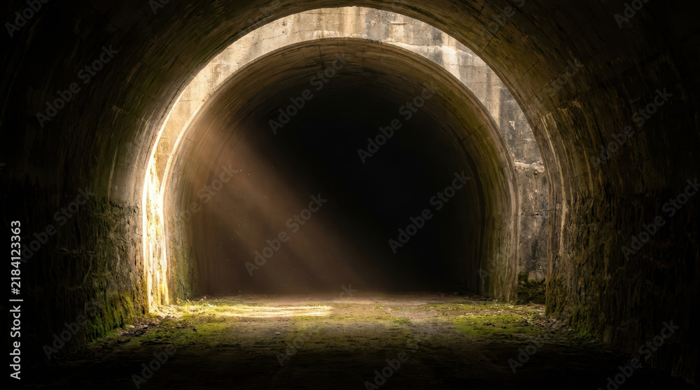Fototapeta premium Dramatic light hitting mouth of deep tunnel creates mysterious passage through weathered stone and shadow