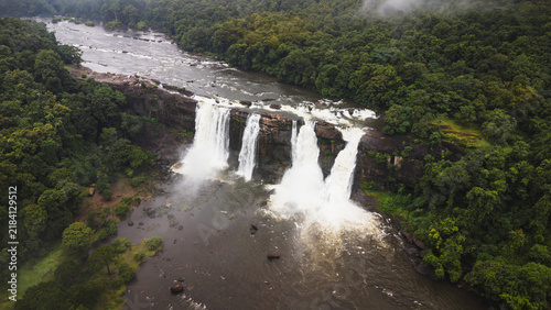Photography Athirappilly Waterfalls flowing through lush tropical forest in Kerala