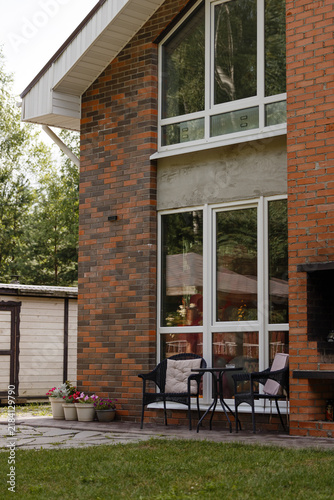 Photography Close view of modern house corner showing red and dark brown brickwork, large wh