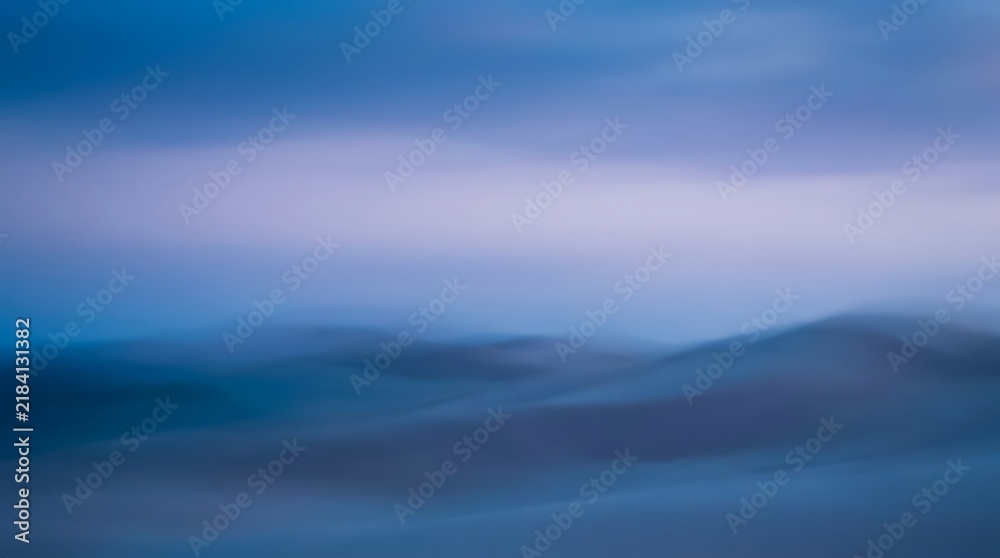 Fototapeta premium Abstract blurred background of rolling blue hills at twilight with abstract landscape twilight background atmosphere