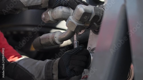 Worker connecting hydraulic hoses on heavy transport equipment