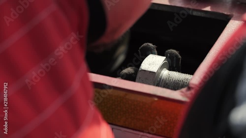 Worker installing large bolt on heavy transport equipment