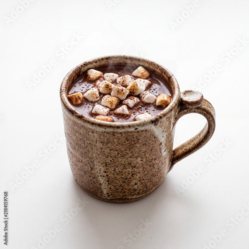 Stoneware mug of hot chocolate with marshmallows on white background