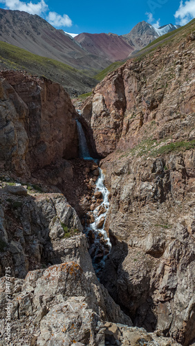 Waterfall Flowing Through Rocky Mountain Canyon