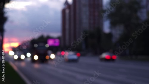 Cinematic view of urban traffic at dusk with blurred moving vehicles and city lights, representing modern city life, transportation and metropolitan atmosphere