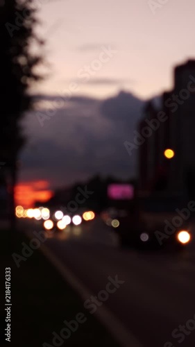 Abstract blurred view of city traffic at dusk with soft bokeh lights, moving vehicles and urban atmosphere creating a versatile background for media, advertising and modern design projects