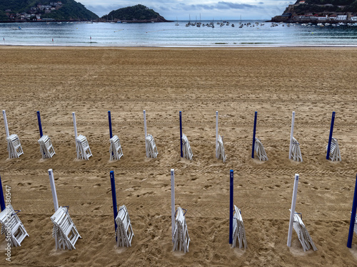 Empty beach chairs lining la concha beach