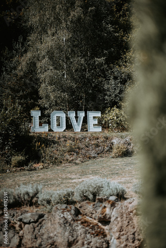 Décoration de mariage en extérieur avec grandes lettres LOVE au cœur d'un jardin