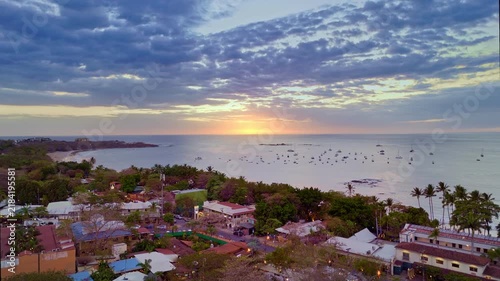 Aerial drone establishing shot of Tamarindo Costa Rica coastal town at sunset with boats anchored in the bay