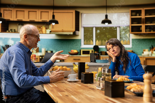 Canvas Print Fed up wife shows boredom and discomfort with retired life monotony while her husband keeps talking, creating a realistic moment of marital displeasure
