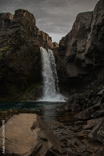 Waterfall cascading between dramatic rocky cliffs in Iceland