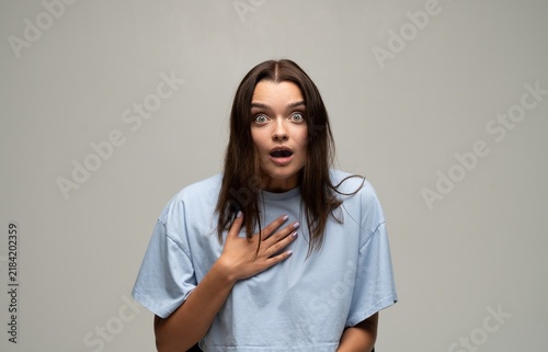 Фотография Young woman reacting with wide-eyed surprise, shocked expression showing disbeli