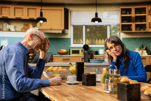фотографія Distant and unamused wife feels drained as her elderly husband keeps speaking during a morning meal, with homemade breakfast framing a strained retirement relationship and her fed-up mood