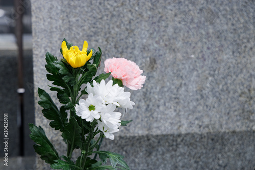墓石にお供えされた菊やカーネーションの色鮮やかな仏花