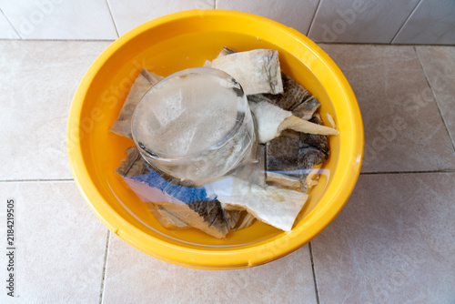 Foto Soak the cod in a yellow-colored bowl with fresh water, using an ice block