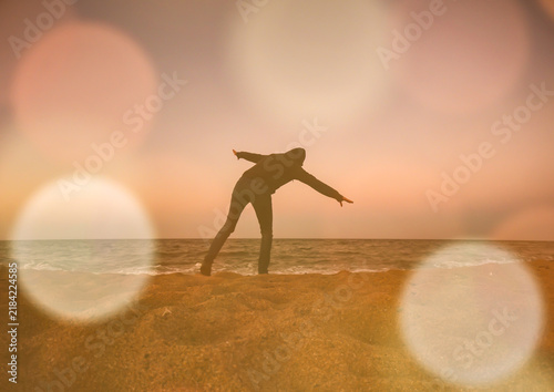 Person enjoying the beach in the evening with lens glare, in warm pastel colors.