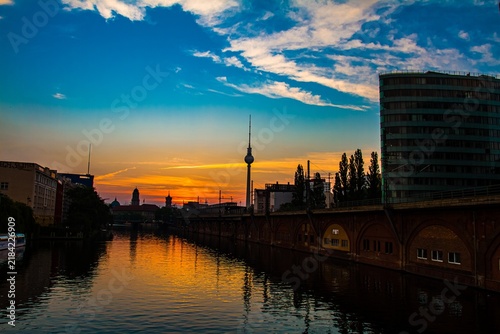 Cityscape at sunset with river and modern buildings