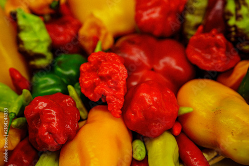 Colors of various peppers arranged in a bowl showcasing different shapes and sizes in a market setting