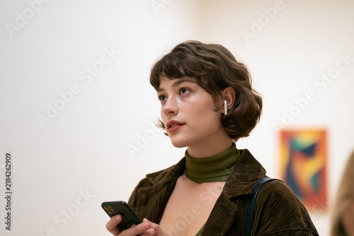 Woman Using Smartphone Audio Guide in Modern Art Gallery