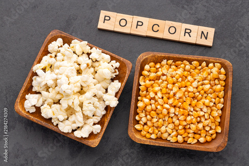Comparison between popping corn and ready-to-eat popcorn, with minimalist composition and space for text in stock photography.
