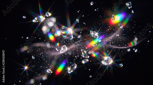 Iridescent rainbow prism sparkle light glow particles floating in a deep pure black background