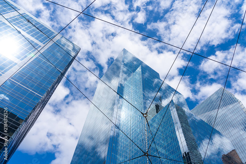 A low angle view of modern glass skyscrapers through the streetcar overhead lines. 