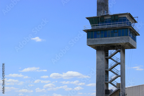 Bild auf Leinwand Foreboding concrete security watchtower in front of a bright blue sky