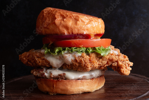 Crispy fried chicken and burger patty sandwich on bun