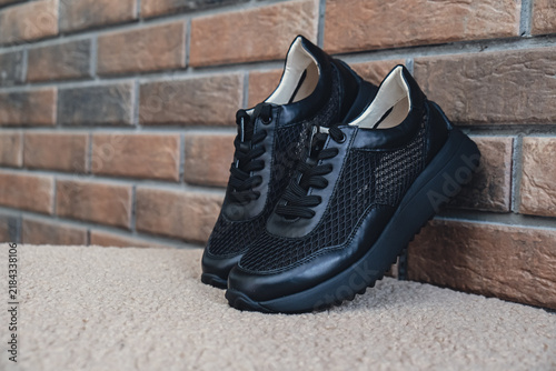 Elegant black leather womens shoes blank product for branding displayed. New casual female sneakers no-brand footwear e-commerce. No logo product unbranded fashion