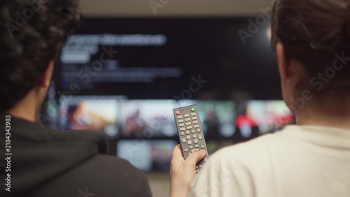 Relaxed couple navigating streaming platform on smart TV to find film for movie night