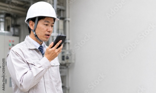 Plakat 工場でスマートフォンに音声メモを録音し作業内容を記録する男性作業員