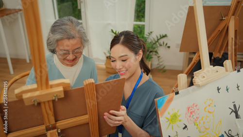 Картината върху платно Elderly senior woman taking part in a therapeutic painting activity at a nursing home