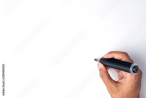 Hand holding a black marker pen to write against a blank white background. Copy space for text.