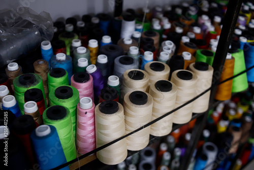 Bild auf Leinwand Colorful Sewing Threads Spools Displayed on Shelves in Textile and Garment Suppl