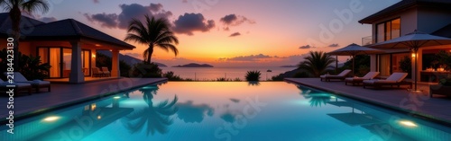 Luxurious sunset view over an infinity pool with tropical villas and palm trees.