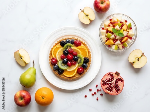Fresh fruit tart with citrus and berries served with bowl of fruit salad