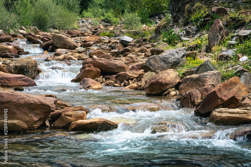 Senderismo por los Pirineos en el Valle de Aran. Caminando junto al río con pequeñas cascadas de agua