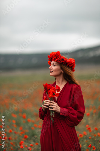 Woman poppies dress posing gracefully in vast red poppy field copy space