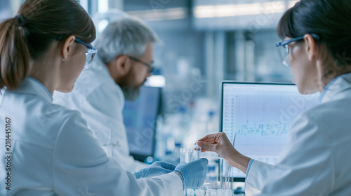Focused scientists engaged in research activity within a modern laboratory environment Generative AI