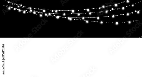 Glowing white string lights hanging against a black background