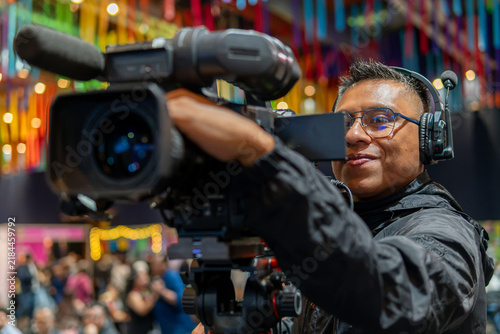 Cameraman filming live event production with professional video camera