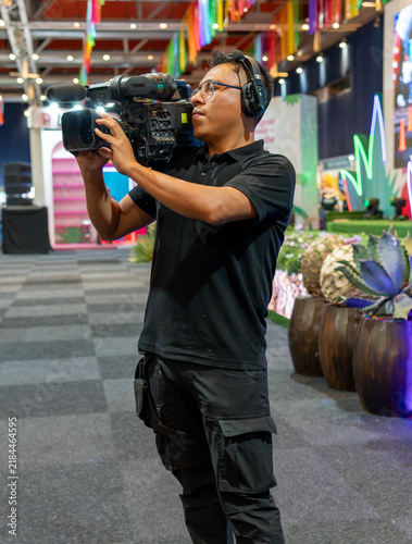Cameraman filming live event production with professional video camera